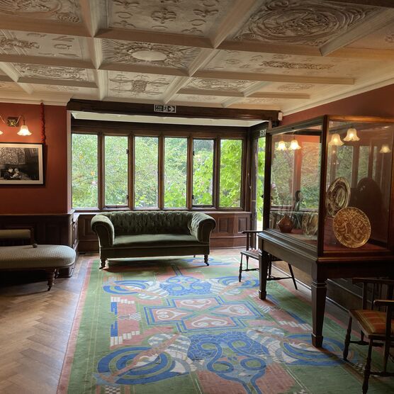Living room with decorated ceiling, sofa and display case