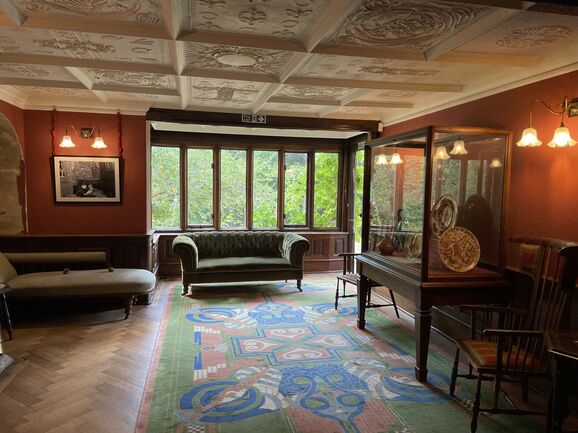Living room with decorated ceiling, sofa and display case
