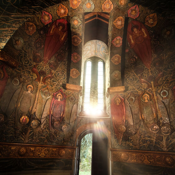 The Chapel interior with the sun shining through a window, casting the interior into gloom in comparison