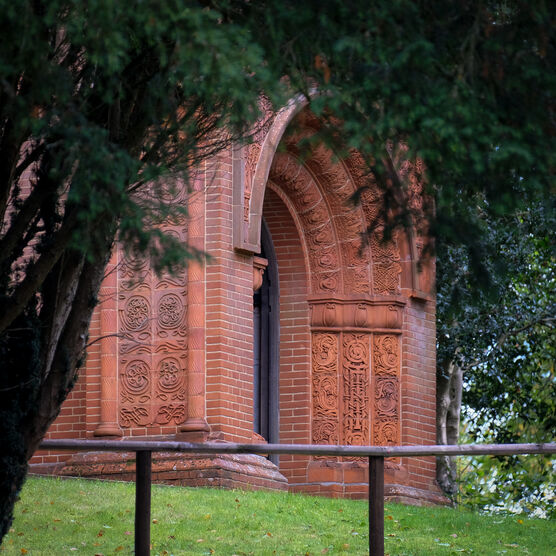 The chapel entrance exterior, the door is framed by a large arch depicting faces of angels