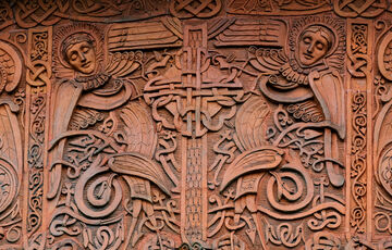 Terracotta panels on outside of chapel, featuring celtic symbols and two angels