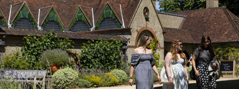 Three women walking in front of the Historic Gallery at Watts Gallery