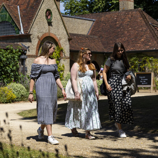 Three women walking in front of the Historic Gallery at Watts Gallery