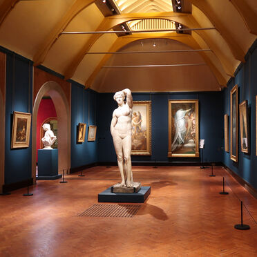 The inside of the gallery with framed paintings and sculptures
