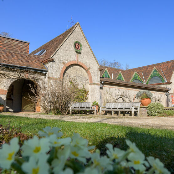 Outside of Watts Gallery building with flowers in foreground