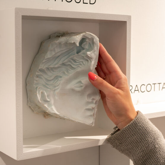 Close-up of a hand touching rubber mould of a sculpture