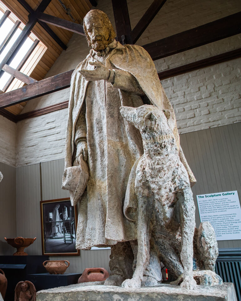 A plaster model of Alfred Lord Tennyson looking at his hand with his dog by his side