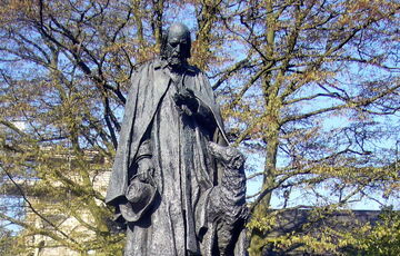 Bronze statue of a man and his dog on a concrete plinth