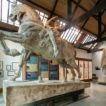 Large sculpture of a man riding a horse in gallery