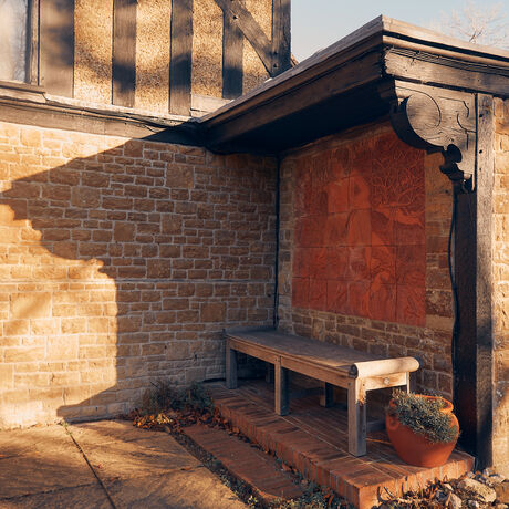 Terracotta tiled nook with wooden bench