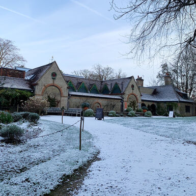 The beige, triangular roofed building covered in a sprinkling of snow