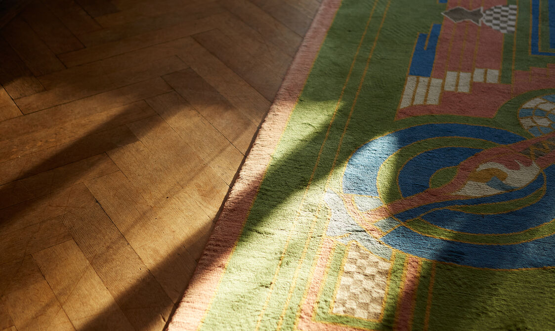 A wooden floor and patterned carpet