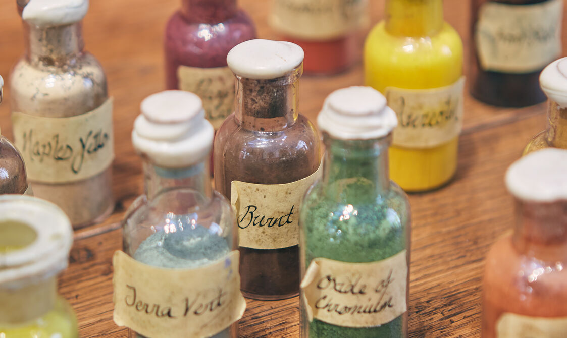 Glass bottles of paints on a wooden surface