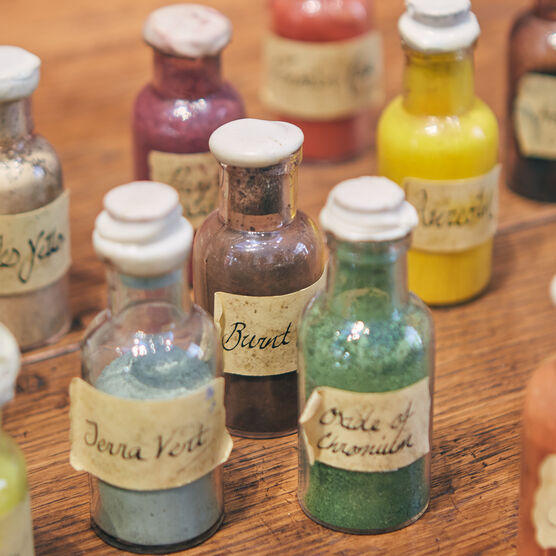 Glass bottles of paints on a wooden surface