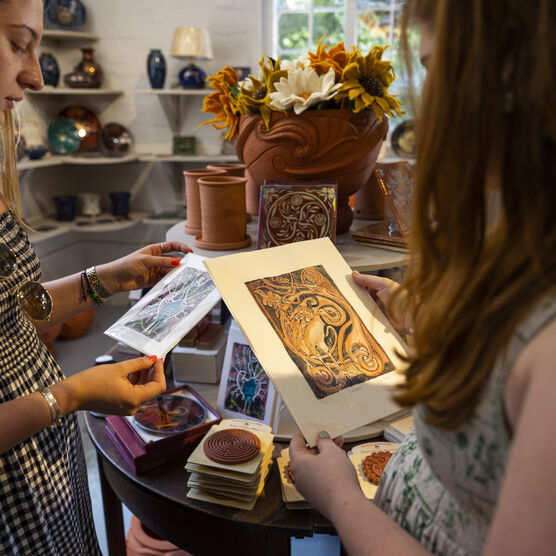 Two visitors browse prints in Shop