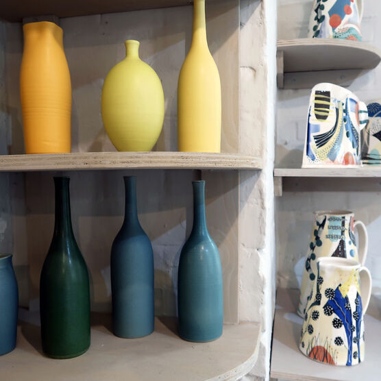 Brightly coloured vases on shelf in Shop