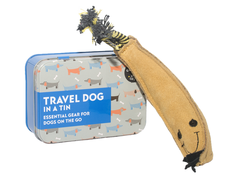 Product photograph of shop items. On the left is a grey and blue tin with cartoon dogs printed over it, and on the right is a dog toy that is shaped like a banana with a smiley face on.