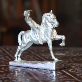 A silver paperweight in the form of George Watts's famous Physical Energy sculpture