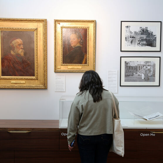 A young woman looks into the display cabinet in the Compton Studio