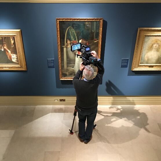 A man films a painting
